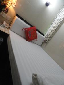 una nevera blanca con una almohada roja en Paris Guest House, en Hong Kong