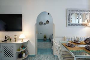 ein Wohnzimmer mit einem Tisch und einem Esszimmer in der Unterkunft Dar Badr in Tangier