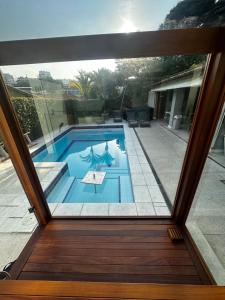 a swimming pool viewed through a glass door at Icaraí Bed & Breakfast in Niterói