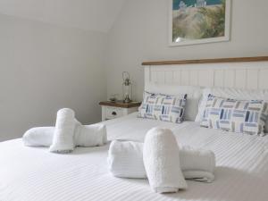two beds in a bedroom with white sheets and pillows at Flip Flops in Reighton