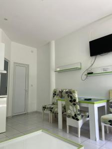 Una sala de estar con una mesa y sillas y un televisor. en Apartmani Jovana, en Soko Banja 11 fotos más