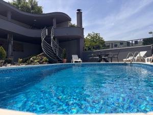 a large swimming pool in front of a house at Villa Mostar - Resort Rozic in Mostar