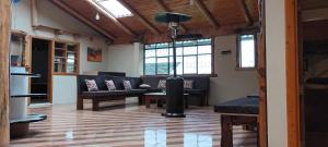 una sala de estar con sofás, mesas y ventanas en Campestre Saraguros en Cuenca