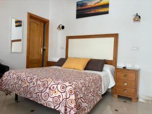 Hostal Los Arcos في تشايبيونا: غرفة نوم بسرير وخزانة خشبية