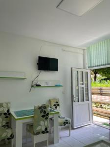 Una habitación con una mesa y sillas y un televisor. en Apartmani Jovana, en Soko Banja