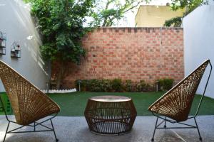 d'une terrasse avec 2 chaises, une table et un mur en briques. dans l'établissement Valentin House, very spacious and cozy., à San Luis Potosí