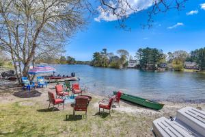 a group of chairs and tables next to a river at Cottage on Private Pond with Beach in Wareham in Wareham