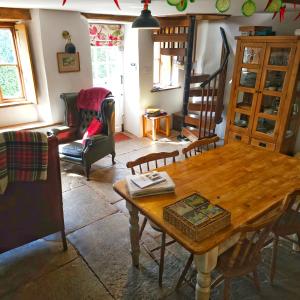 een woonkamer met een houten tafel en stoelen bij Woodview - cosy 1840s cottage in Chew Valley and Mendip AONB in Compton Martin