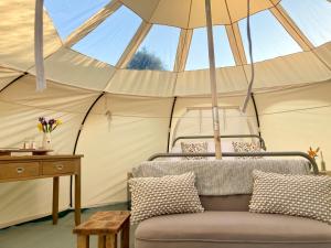 a room with a couch in a tent at Luxury Stargazing Glamping - Seren Hardd with Hot Tub in Llanidloes