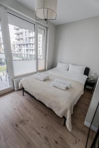 1 dormitorio con 1 cama grande y 2 toallas. en Gdansk Seaside Apartments en Gdansk