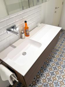 un lavandino in bagno con una bottiglia di sapone di Your homestay in a bibliophile mansion ad Anversa