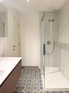 a bathroom with a shower with a glass door at Your homestay in a bibliophile mansion in Antwerp