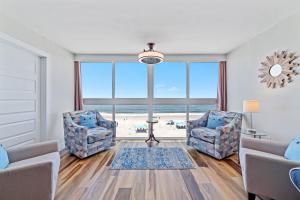 ein Wohnzimmer mit zwei Sesseln und Blick auf den Strand in der Unterkunft Edgewater West Unit 44 in Gulf Shores