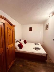 Schlafzimmer mit einem Bett mit weißer Bettwäsche und roten Kissen in der Unterkunft Meadow Hill in Žrnovo