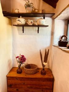 ein Zimmer mit zwei Vasen auf einem Holztisch mit Regalen in der Unterkunft Meadow Hill in Žrnovo