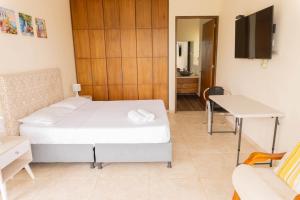 1 dormitorio con cama, mesa y escritorio en Casa Campestre - Pet Friendly - Green Energy, en Anapoima