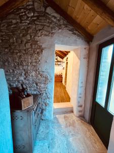a kitchen with a stone wall and a doorway at Meadow Hill in Žrnovo