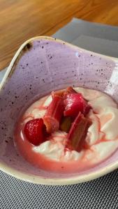 a bowl of dessert with strawberries and whipped cream at Brooklynn Guest House in Grantown on Spey
