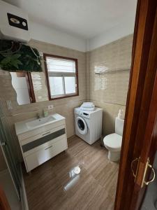 a bathroom with a toilet sink and a washing machine at Juanita Flat in Tazacorte