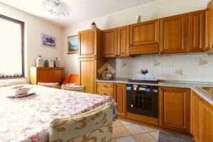 a kitchen with wooden cabinets and a table in it at B&B Marienn in Gavardo