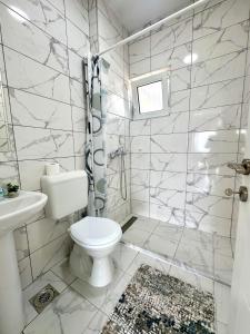 a white bathroom with a toilet and a sink at D&A Apartments in Ohrid +33 photos