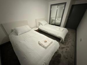 チェルムスフォードにあるLuxurious 3 Bedroom Penthouse in City Centre - Sleeps 8!の鏡付きの小さな部屋のベッド2台