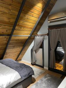 a bedroom with a wooden ceiling and a bed at BİTEK BUNGALOV in Trabzon