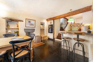 Una cocina y una sala de estar con mesa y sillas. en Longmire Yeat Cottage, en Troutbeck