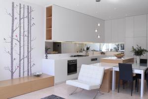cocina con armarios blancos, mesa y sillas en Boutique Stays - The Residence, en Melbourne