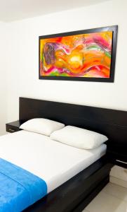 - une chambre avec un lit orné d'une peinture murale dans l'établissement Hotel Casa Grande Riohacha Inn, à Ríohacha