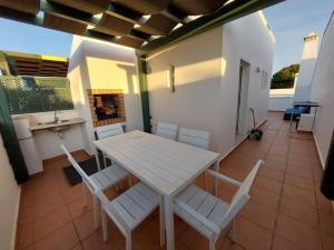 einen Tisch und Stühle auf dem Balkon eines Hauses in der Unterkunft Casa Água & Sal in Castro Marim