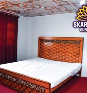 uma cama com uma cabeceira de madeira num quarto em Skardu City Guest House em Skardu