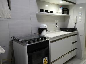 a small kitchen with a stove and a sink at APARTAMENTO EM GARANHUNS PERTO De TUDO in Garanhuns +8 photos