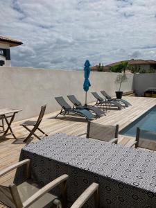 a patio with chairs and a table and a pool at ANGRESSE Villa Chris à 10 min d'HOSSEGOR in Angresse