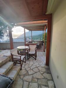 - un patio avec une table et des chaises sur un sol en pierre dans l'établissement Spartila Apartments, à Dhërmi