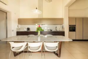 a kitchen with a large marble table with white chairs at Villa Il Fico in Cavriglia +27 photos