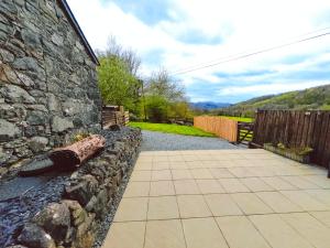 a stone retaining wall next to a walkway at Dolgun Uchaf Guesthouse and Cottages in Snowdonia in Dolgellau