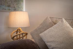 una lampada seduta accanto a un divano con cuscini di Grassholm Cottage with Hot Tub - Dog Friendly a Haverfordwest Altre 3 foto