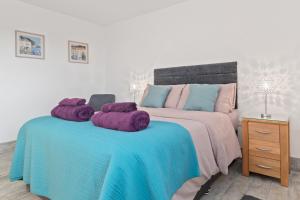 una camera da letto con un letto e asciugamani viola di Grassholm Cottage with Hot Tub - Dog Friendly a Haverfordwest