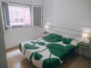 ラスパルマス・デ・グランカナリアにあるAqui te Esperoのベッドルーム1室(緑の葉柄のベッド1台付)