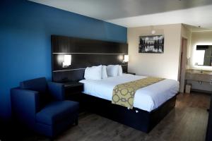 Pokój hotelowy z łóżkiem i krzesłem w obiekcie Baymont Inn & Suites w mieście Manning