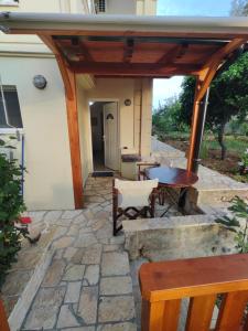 un patio de piedra con pérgola de madera en Spartila Apartments, en Dhërmi
