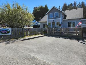 una casa con una valla de madera delante de ella en Idlewild Manor Vacation home, en Gold Beach