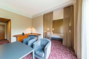 um quarto de hotel com uma mesa e cadeiras e uma cama em NH Collection Prague em Praga