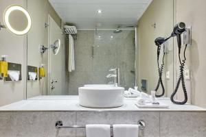 ein Bad mit einem Waschbecken und einer Dusche in der Unterkunft NH Collection Prague in Prag