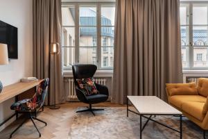 a living room with a couch and a chair at Scandic Grand Central Helsinki in Helsinki