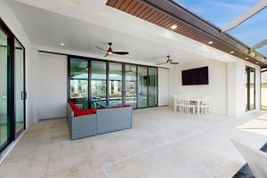 ein offenes Wohnzimmer mit Glastüren und einem Flachbildfernseher in der Unterkunft Sunset Serenity in Cape Coral