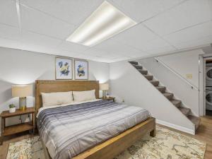 匹兹堡Bloomfield, Pittsburgh Large and Accessible 3 Bedroom Apr with Free Parking的一间卧室设有一张床和一个楼梯