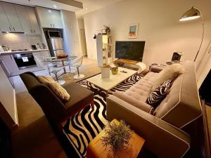 a living room with a couch and a table at Redfern One Bedroom Apartment with Views in Sydney