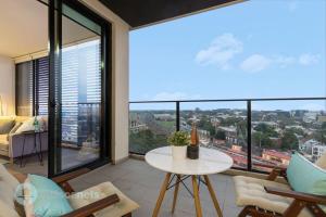 a living room with a table and a large window at Redfern One Bedroom Apartment with Views in Sydney
